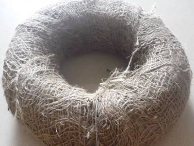 A coil of baling wire packed in plastic films inside and hessian cloth outside.