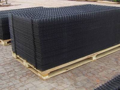 Welded mesh panels are packed in wooden pallets on the ground.
