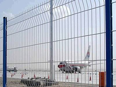 Welded mesh panel as fencing in airport; behind the fence is a plane.
